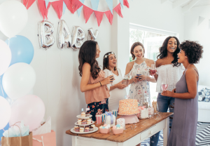women at baby shower near table of food